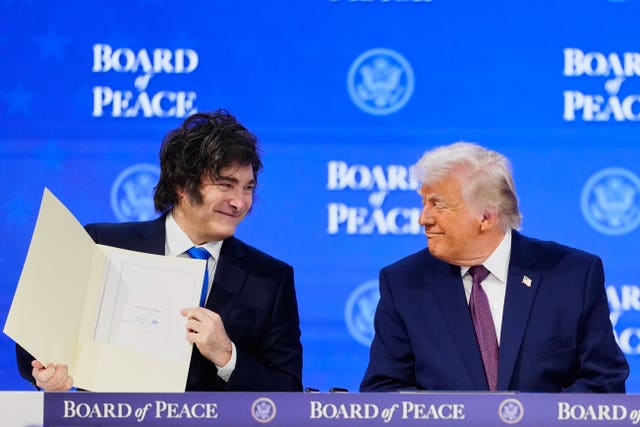 Donald Trump watches Argentinian President Javier Milei during a signing ceremony on his Board of Peace initiative