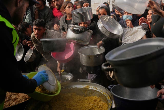 Palestinians wait to receive donated food at a distribution centre in Khan Younis, southern Gaza 