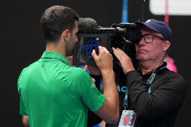 Novak Djokovic signs a camera lens