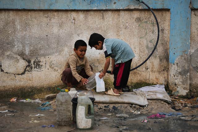 Palestinian children filling water containers