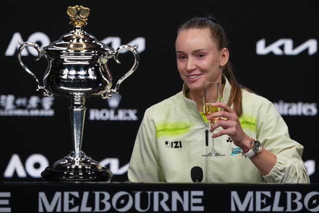 Elena Rybakina holds a glass of champagne during a press conference