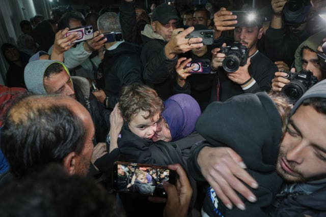 A woman embraces one of her grandsons after arriving in Gaza following the reopening of the Rafah border crossing