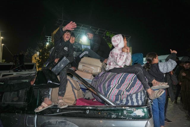 The family of a 60-year-old heart patient carry her belongings after she and 11 others were allowed into Gaza from Egypt following the long-awaited reopening of the Rafah border crossing