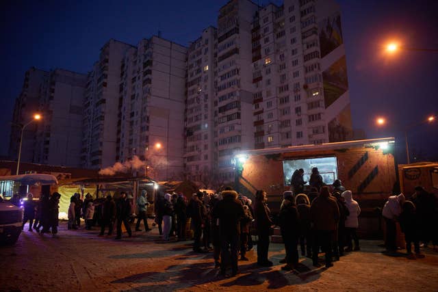 People stand in line for free hot meals in Kyiv