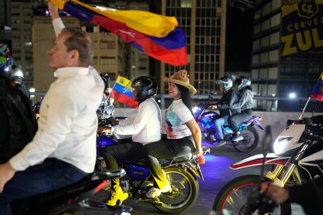 Maria Oropeza and Juan Pablo Guanipa riding motorbikes through Caracas