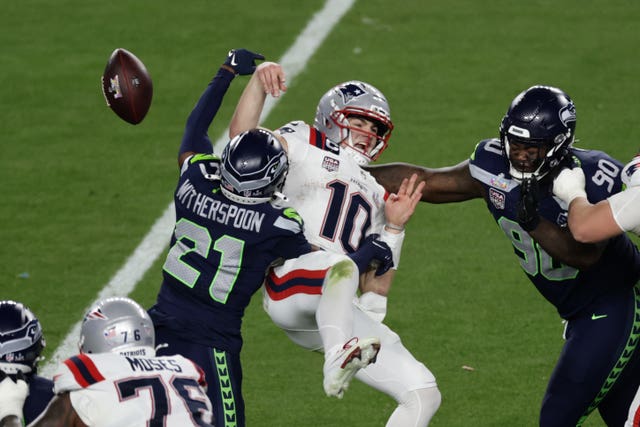 Seattle Seahawks cornerback Devon Witherspoon (21) forces a fumble against New England Patriots quarterback Drake Maye 