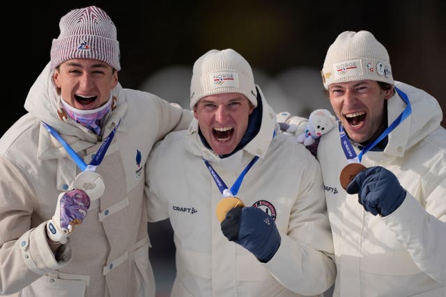Silver medalist Eric Perrot, of France, from left, gold medalist Johan-Olav Botn, of Norway, and bronze medalist Sturla Holm Laegreid, of Norway, pose after the men’s 20-kilometer individual biathlon race