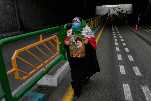 A woman carries a poster of the Iranian Supreme Leader Ayatollah Ali Khamenei