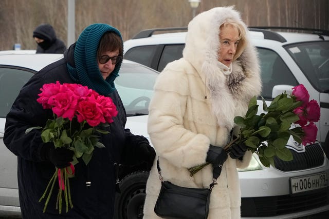 Alexei Navalny’s mother Lyudmila Navalnaya, left, and his mother-in-law Alla Abrosimova holding flowers