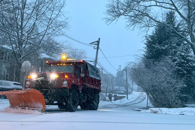 A plough starts removing snow from a residential street in New Jersey 