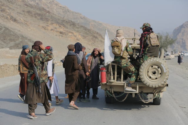Afghan Taliban soldiers gather on the Afghan side of a border crossing with Pakistan