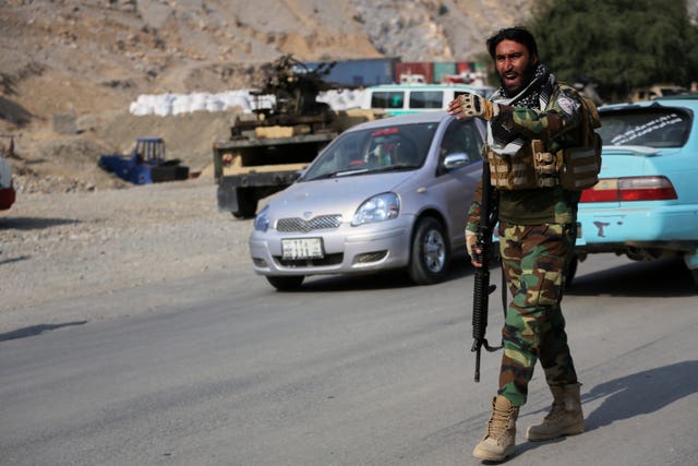 An Afghan Taliban soldier gives instructions to drivers on the Afghan side of the Torkham border crossing with Pakistan 