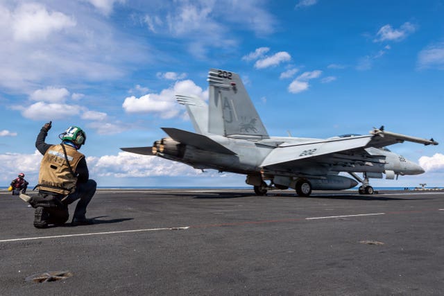 This image provided by US Central Command shows a US Navy sailor signalling the launch of an F/A- 18F Super Hornet on the USS Gerald R Ford in support of Operation Epic Fury, on Sunday