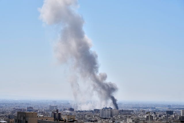 A plume of smoke rises after a strike in Tehran, Iran 