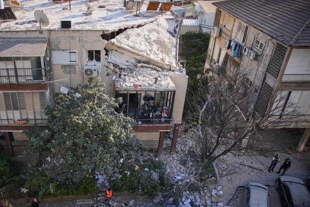 Officers from Israel’s Home Front Command inspect a damaged apartment building after an Iranian missile strike in Ramat Gan, Israel