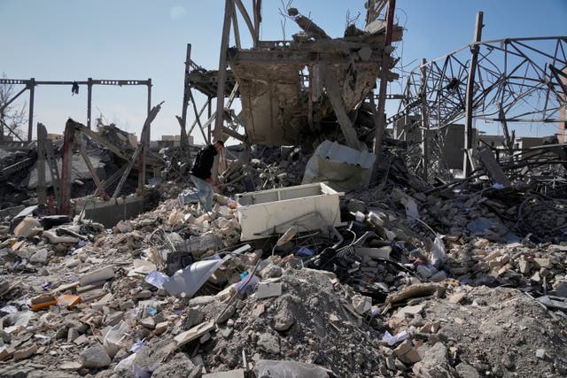 A man walks on the rubble of a police facility struck during the US–Israeli military campaign in Tehran, Iran 