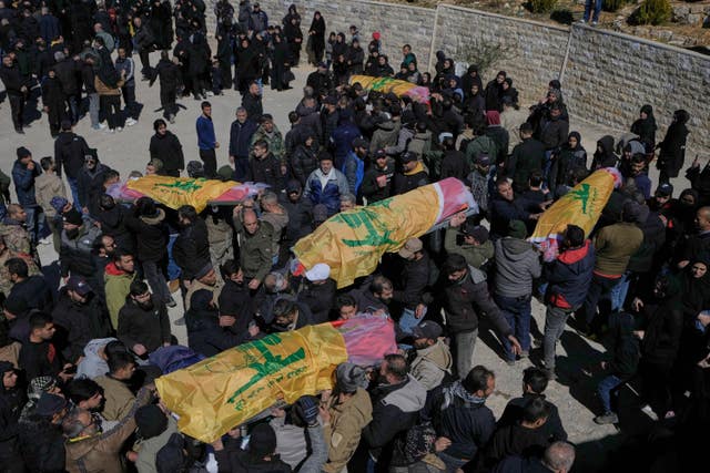 Mourners carry the bodies of Hezbollah fighters who were killed by Israeli airstrikes during their funeral procession in Khraibeh village, eastern Lebanon