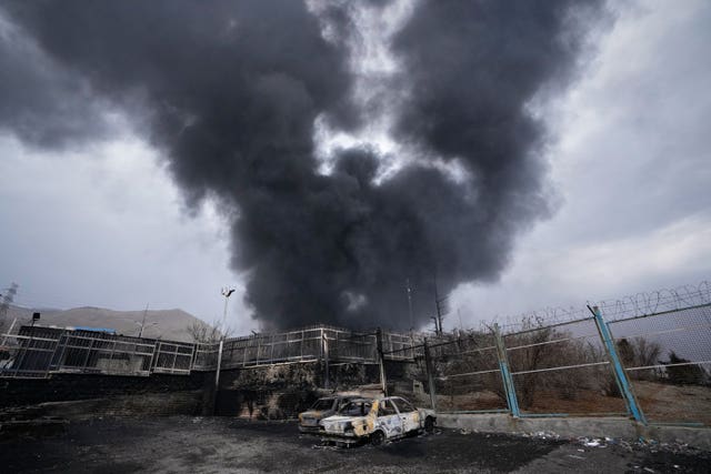 A thick plume of smoke rises from an oil storage facility hit by a US-Israeli strike in Tehran