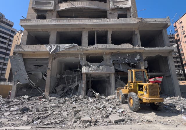 A bulldozer removes the wreckage of destroyed shops at a building that was hit by an Israeli air strike in Dahiyeh, Beirut’s southern suburbs, Lebanon