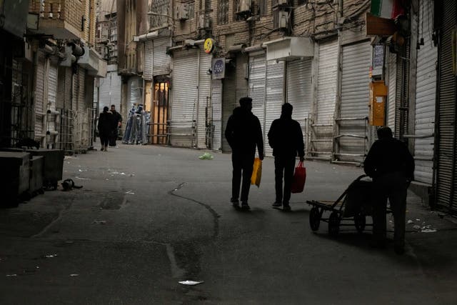 People walk along the mostly empty Tajrish traditional bazaar, where most shops are closed, in northern Tehran, Iran 