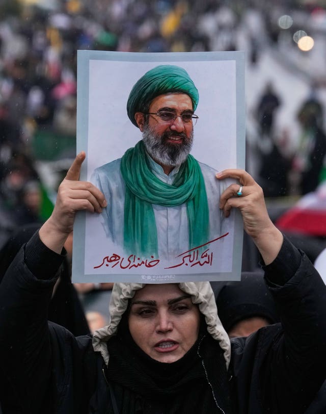 A woman holds up a poster of the Iranian Supreme Leader Ayatollah Mojtaba Khamenei