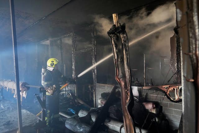 Firefighters tackling a blaze in a burned out building