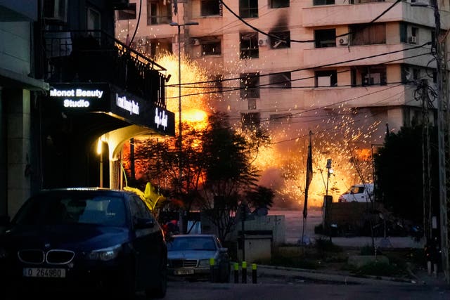 Explosions erupt from a building after an Israeli strike in Beirut