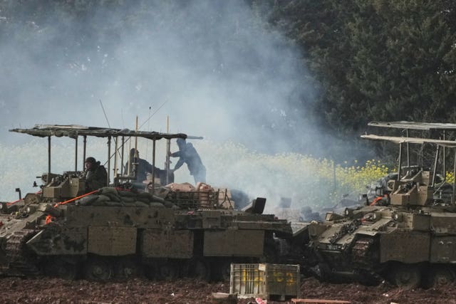Israeli soldiers atop an APC in northern Israel near the border with Lebanon