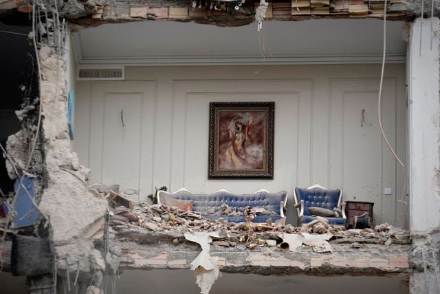 Rubble covers the furniture of a destroyed living room in a residential building hit in an earlier US-Israeli strike in Tehran, Iran