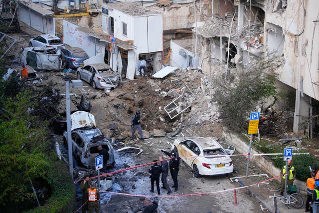 Israeli security and rescue forces respond at the site of an Iranian missile strike in Tel Aviv, Israel