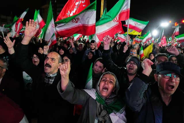 Pro-government supporters chant slogans and wave Iranian flags during a rally in western Tehran 