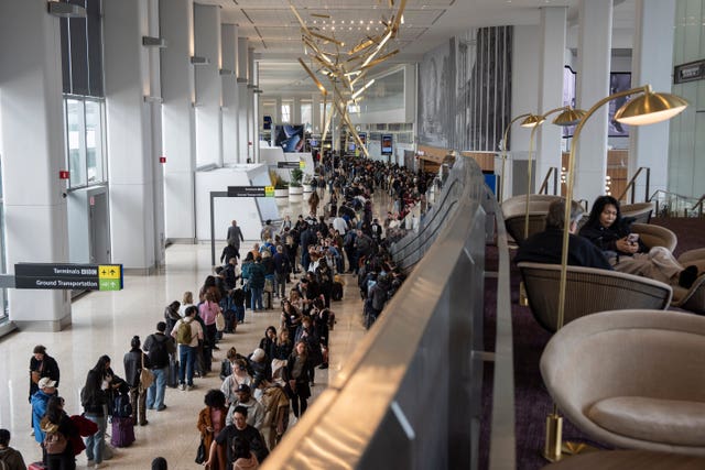 Travellers wait in a TSA line at LaGuardia Airport in New York