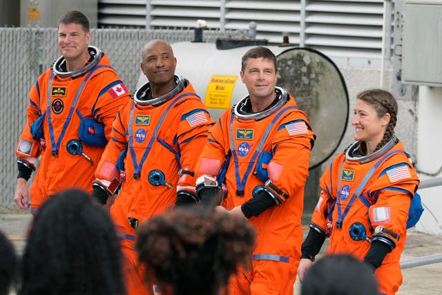 Astronauts, from left, Mission Specialist Jeremy Hansen, of Canada,, Pilot Victor Glover, Commander Reid Wiseman, and Mission Specialist Christina Koch pose for a photo after leaving the Operations and Checkout Building