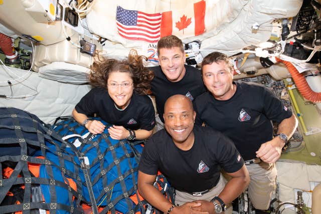 A group photo inside the Orion spacecraft as the crew make their way home 