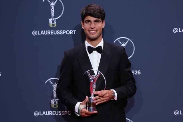 Carlos Alcaraz smiles after collecting a Laureus award