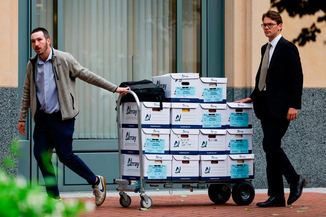 Boxes of materials are wheeled into the Dellums Federal Building