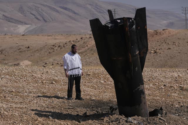 A man looks at the wreckage of an Iranian missile that landed near the West Bank city of Jericho