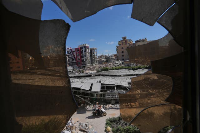 Buildings damaged by Israeli strikes are seen through shattered glass from the Jabal Amel Hospital in the southern port city of Tyre, Lebanon