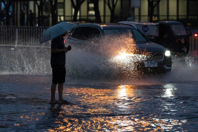 A man walks through a flooded junction in Beijing