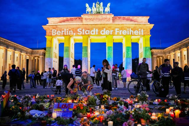 People look at tributes in front of the Brandenburg Gate after the attack in Berlin