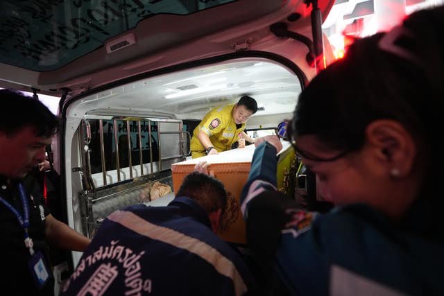A coffin is transported from the scene