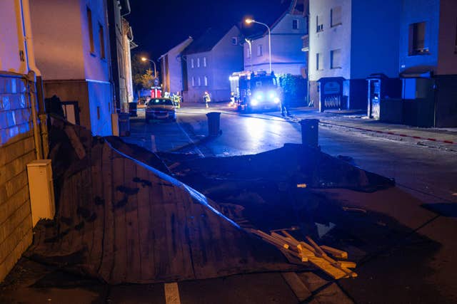 Firefighters stand in front of damaged houses in Wetzlar, Germany