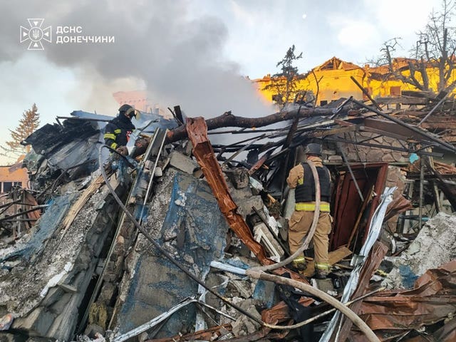 Emergency services personnel work to extinguish a fire following a Russian guided bomb strike in Sloviansk 
