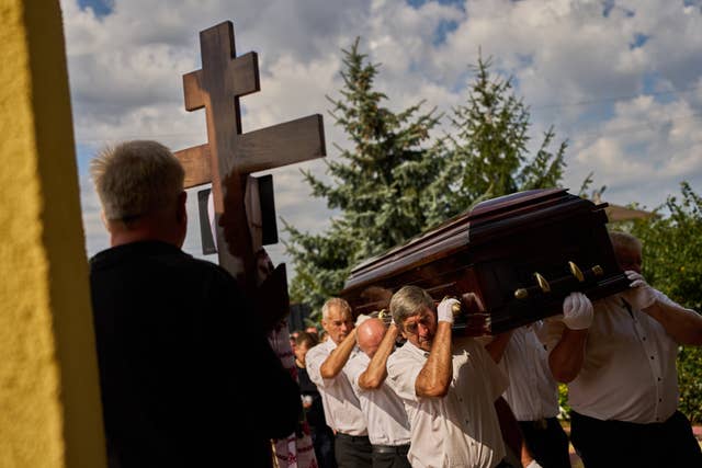Pallbearers carry a coffin on the outskirts of Kyiv 