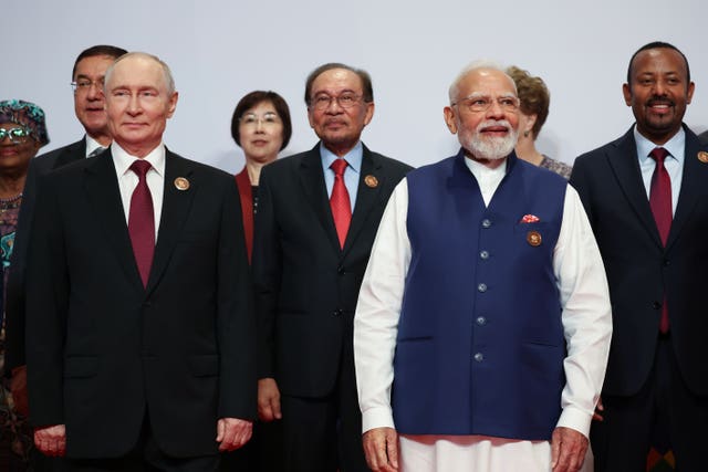 Vladimir Putin and Narendra Modi, at the front of a group for a group photo