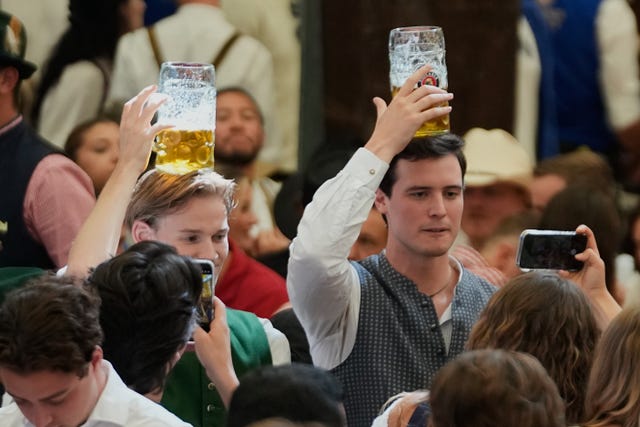 People balance beer mugs on their heads