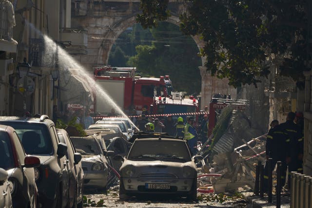 Firefighters work at the scene on the street leading to Hadrian's Gate in central Athens 