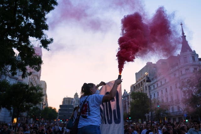 A protester holding a smoking flare