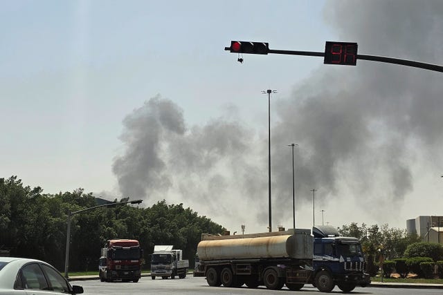 Vehicles travel along a road as black smoke billows from a fire at an oil facility in an industrial area in southern Riyadh