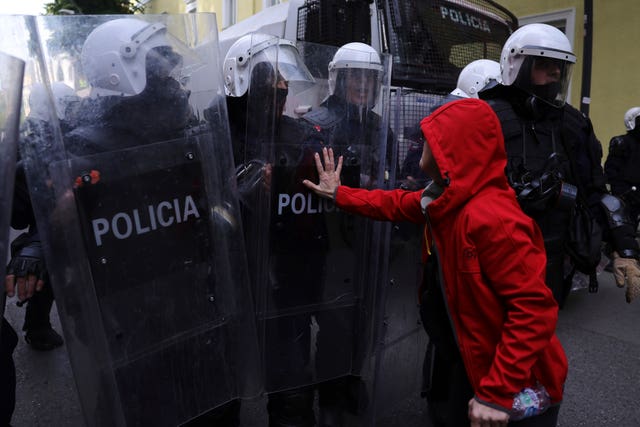 A protester pushes a riot police officer’s shield during an anti-government demonstration in Tirana
